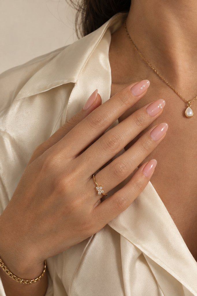 Elegant nude-pink nails with small ivory pearl embellishments.