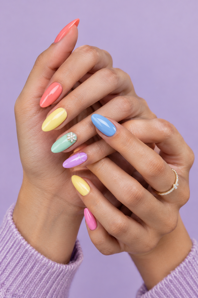 Rainbow pastel acrylic nails displayed on interlaced hands.